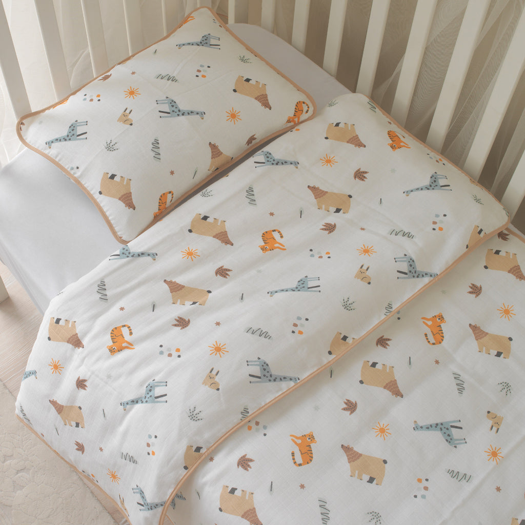 %100 pamuk müslin kumaşın nefes alan dokusu üzerinde aslan, zürafa ve fil figürleri.