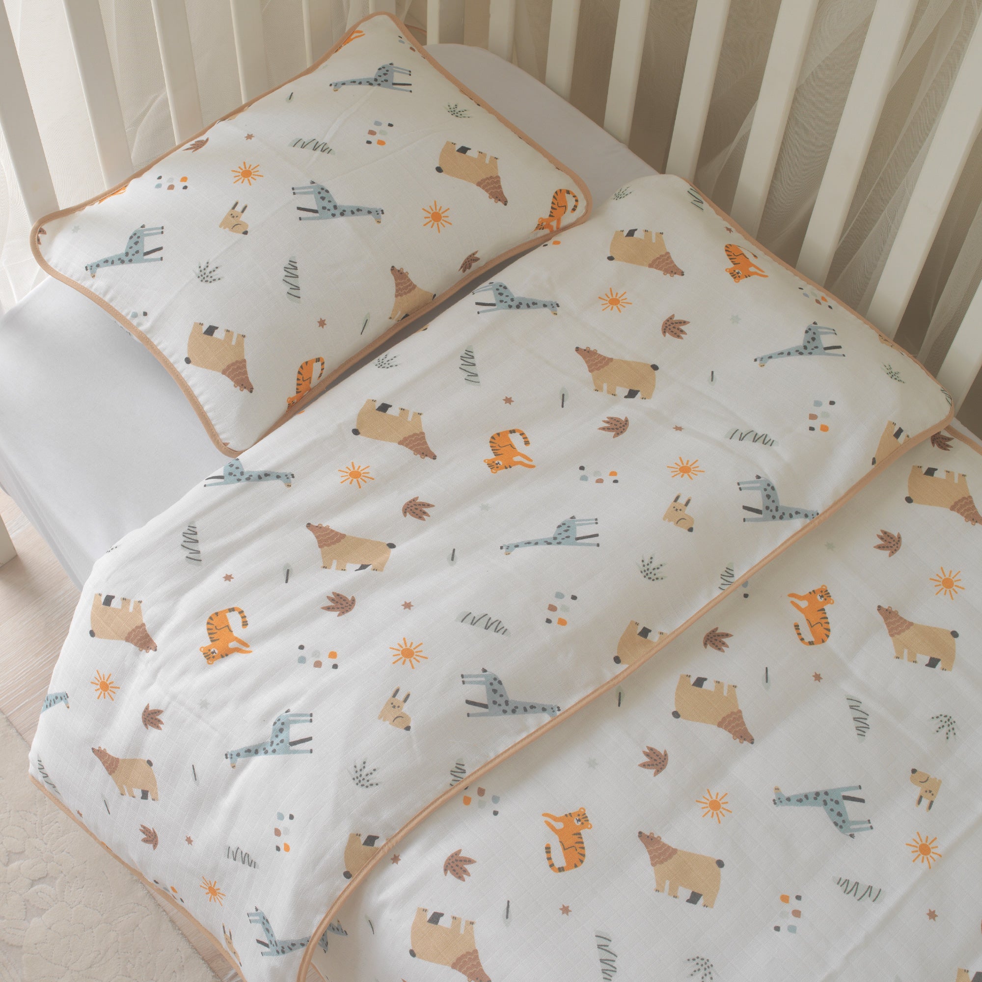 %100 pamuk müslin kumaşın nefes alan dokusu üzerinde aslan, zürafa ve fil figürleri.