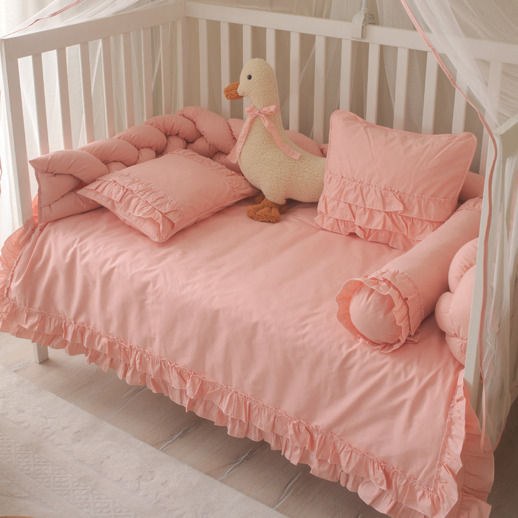 Oyun parkı ve beşik ölçüleri için ideal fırfırlı pembe nevresim ve silindir yastık seti.