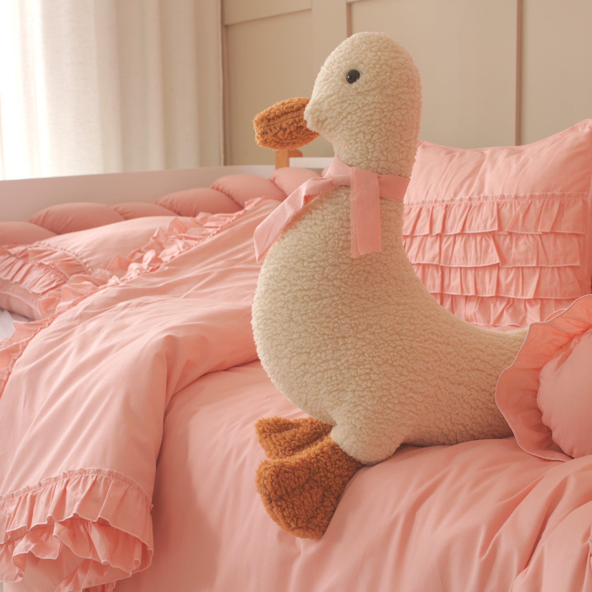 Vintage tarz pembe fırfırlı dekoratif kare yastık ve silindir yastık kombinasyonu.