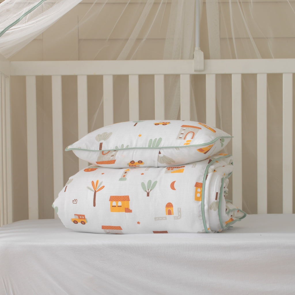 Şehir ve araba desenli müslin bebek nevresim takımı ve yeşil biyeli yastık kılıfı seti.