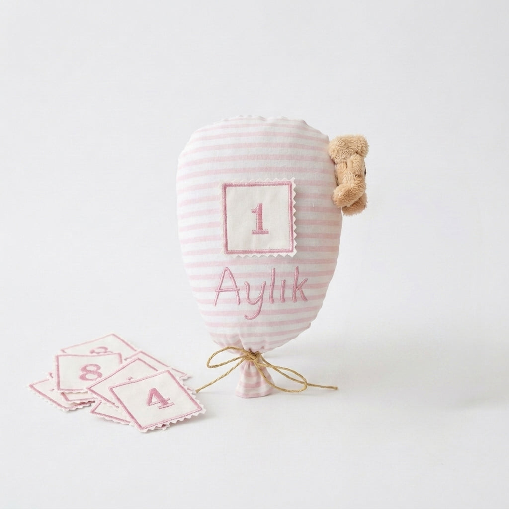 Pembe çizgili ay takip balonu ve 12 aylık numaralı yamalar bir arada