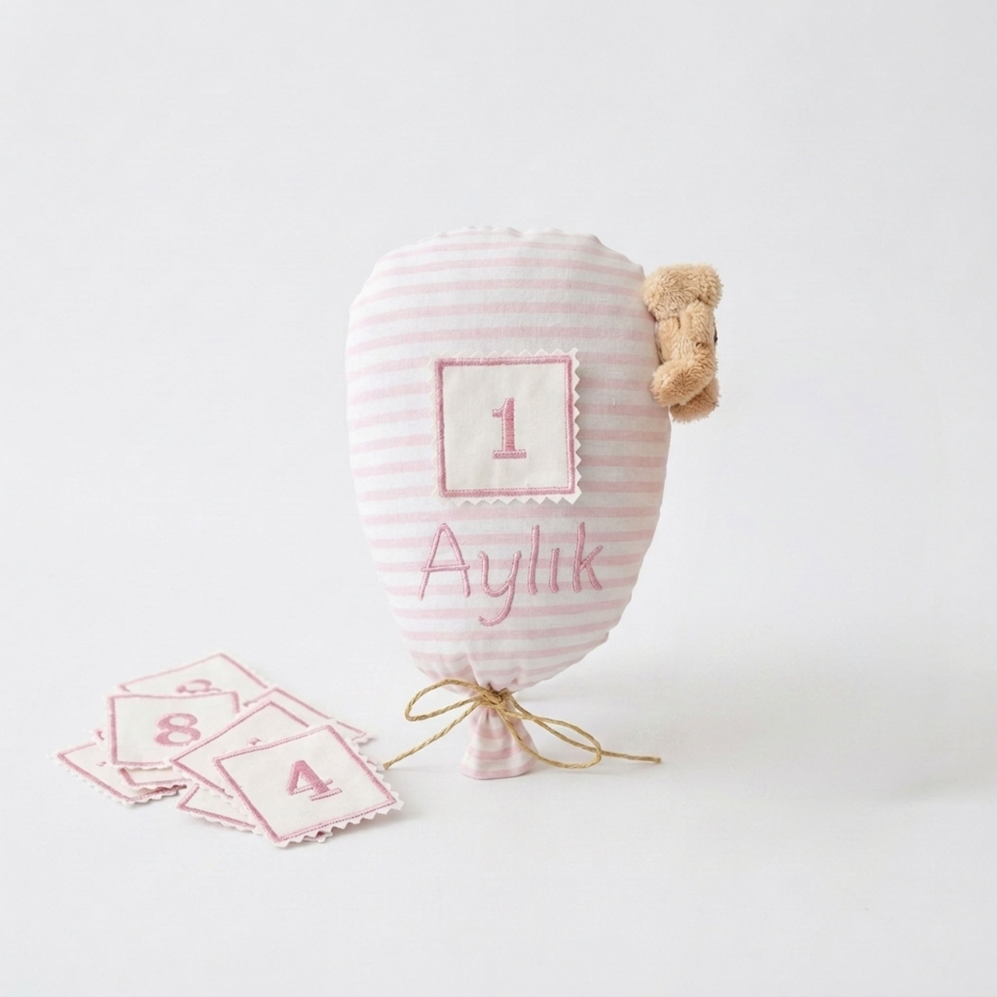 Pembe çizgili ay takip balonu ve 12 aylık numaralı yamalar bir arada