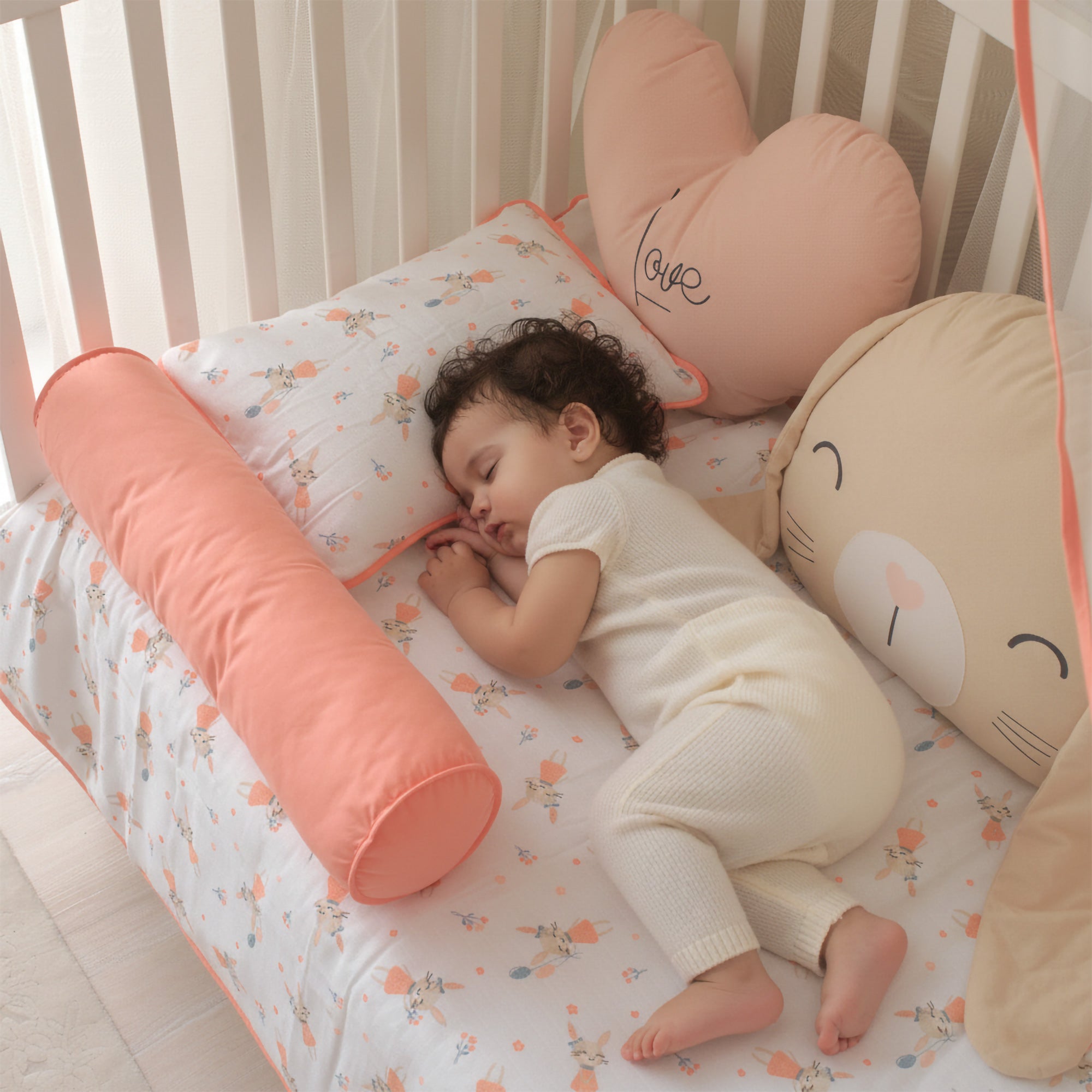 Beşik içinde koruyucu bariyer görevi gören dev Rabbit karakter yastığı.