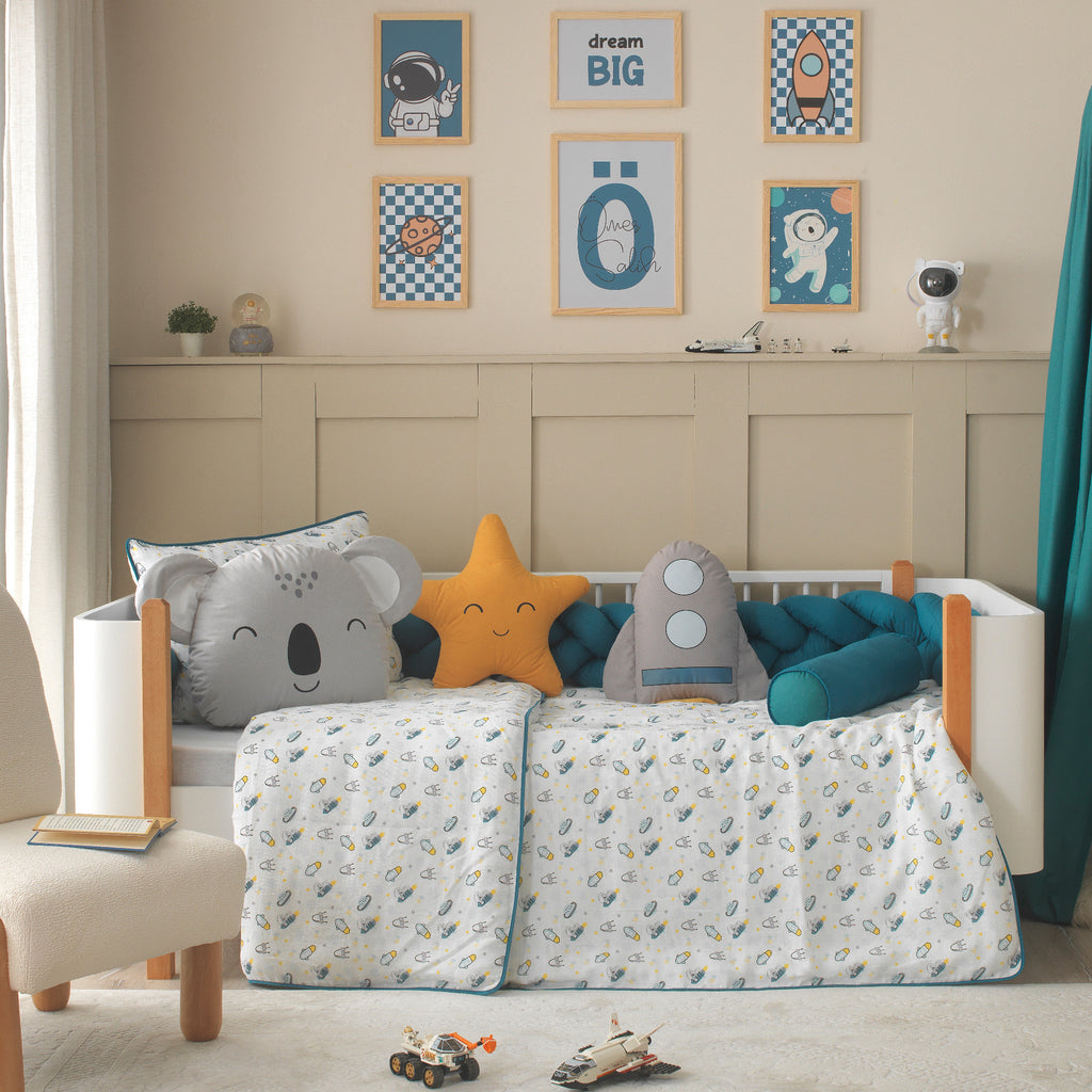 Uzay temalı figürlü uyku arkadaşları; koala, roket ve yıldız yastık detayları.